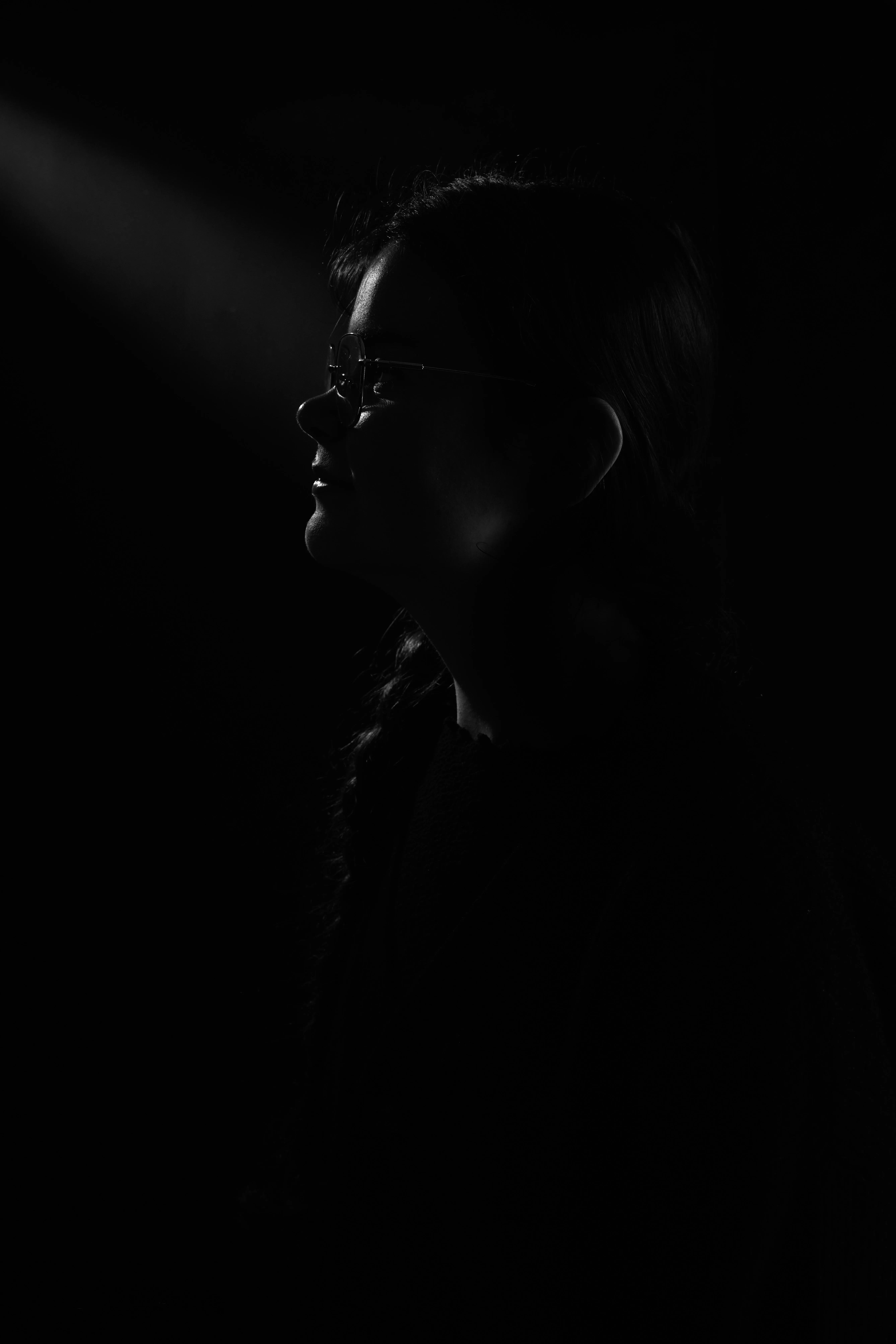 Portrait studio en clair-obscur, lumière sculptant le visage